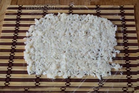 Макису застилаем пищевой плёнкой. На плёнку выкладываем рис.