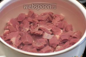 Выложить мясо в кастрюлю объемом 4 литра и залить холодной водой. Варить говядину 1,5 часа с момента закипания на медленном огне, снимая пену.