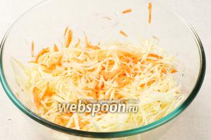 Соединить капусту с морковкой и посолить. Затем хорошо помять руками и оставить на 5-10 минут, чтобы капуста пустила сок и стала мягче.
