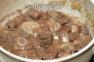 В кастрюле разогреть 3-4 столовые ложки растительного масла и обжарить говядину на сильном огне до получения золотистой корочки.