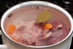 Выложить мясо в глубокую кастрюлю, добавить крупно порезанную морковь, душистый перец и лавровый лист. Залить всё 3 литрами холодной воды, довести до кипения и варить на медленном огне 2 часа, снимая пену.