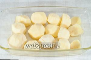 Форму для запекания смажьте сливочным маслом. Уложите на неё картофель разрезами вверх, посолите.