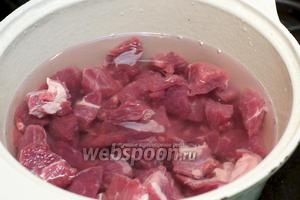 Выложить мясо в глубокую кастрюлю с толстым дном или утятницу и залить 1-1,5 литра холодной воды.