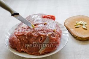 Перед тем, как замариновать мясо — нашпиговываем его чесноком.
Для этого нарезаем соломкой зубчики чеснока,ножом делаем отверстия и в них вкладываем чеснок.