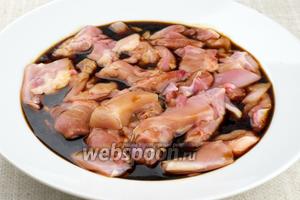 Куриное мясо снять с кости, крупно порезать, залить соевым соусом и оставить мариноваться при комнатной температуре на 40-50 минут.