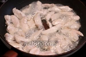 В глубокой сковороде разогреть растительное масло 2 ст.л. и обжарить куриное филе до белого цвета 3-5 минут, затем вместе с выделившимся соком переложить всё в отдельную тарелку.