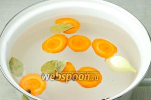 Морковь очистить и нарезать крупными колечками, лук очистить. Овощи залить водой, добавить лавровый лист, душистый перец и варить 30 минут.