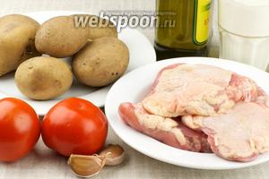 Для приготовления блюда понадобится 5-6 куриных бёдер, картофель, помидоры, кефир, оливковое масло и специи.