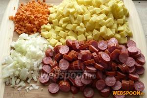 Почистить и порезать кубиками картофель, морковь и лук. Охотничьи колбаски порезать кружочками.