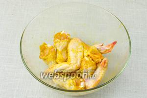 Куриные крылья промыть и обсушить при помощи бумажных салфеток. Натереть приправой карри, посолить и отставить в сторону.