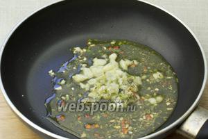 В разогретую сковороду влить 2 столовые ложки оливкового масла, добавить рубленный чеснок и специи. Обжарить 1 минуту.