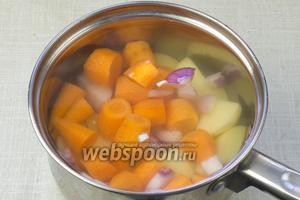 Количество продуктов указано для кастрюли объёмом в 1,5 литра.
В кастрюлю положить картофель, морковь, лук и чеснок. Залить кипятком и немного посолить. Довести до кипения.
