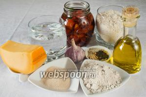 Чтобы испечь батоны, необходимо взять для теста: муку пшеничную и ржаную, дрожжи, воду, сахар, соль, чеснок, оливковое масло; для начинки: вяленые помидоры, сыр твёрдый, ржаную муку; для присыпки семечки подсолнуха и кунжута, мак.