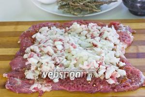 Выкладываем начинку, распределяем её по всему периметру мясного пласта, оставляя место от краёв.