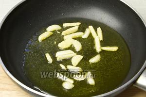 Разогреть сковороду и влить 2 столовые ложки оливкового масла. Выложить чеснок и обжаривать около 2 минут. Затем добавить 1 чайную ложку сахара без горки и подержать ещё 1 минуту.
Следите за тем, чтобы чеснок не подгорел.