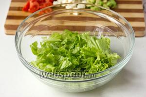 Листья салата моем под проточной водой, лишнюю воду аккуратно промакиваем бумажным полотенцем, нарываем салат в глубокую миску средними кусками.