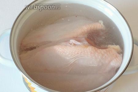 Залить куриное филе холодной водой и отварить до готовности, добавив 0,5 ч. л. соли. Остудить в той же воде, в которой варилось в течение ещё 20 минут.