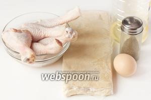 Для приготовления куриных голеней, запечённых в слоёном тесте, нам понадобится предварительно размороженное готовое дрожжевое слоёное тесто, куриные голени, яичный желток, соль, чёрный молотый перец, масло подсолнечное рафинированное.