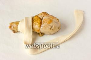 Каждую голень обматываем полосками теста по спирали, слегка отступив от кости с небольшим нахлёстом полосок теста друг на друга.