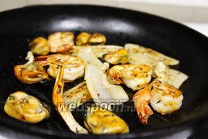 Пора жарить морепродукты! На горячую сковороду влить масло и уложить тимьян, следом уложить хвосты креветок, мидии, кусочки кальмара, клешни рака и хвост. Посолить, изъять тимьян, перевернуть все морепродукты и хорошенько взбрызнуть лимоном. Снять с огня.