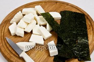 Нарезать сыр прямоугольниками (примерно 2х4 см), а нори разрезать так, чтобы получились длинные полоски.
