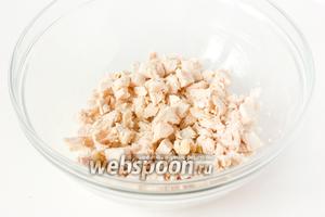 Отвариваем до готовности в подсоленной воде куриное филе. Когда мясо полностью остынет, нарезаем мелкими кубиками и выкладываем в глубокий салатник.