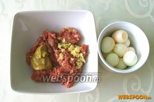 Отварить в крутую и очистить перепелиные яйца. В мясной фарш добавить измельчённый зубчик чеснока, чайную ложку горчицы и соль по вкусу.