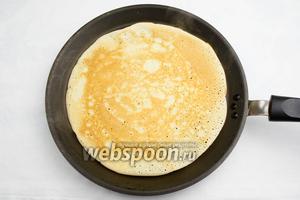 С помощью деревянной лопатки перевернуть блин и продолжить жарить его с другой стороны до готовности (с обратной стороны блин жарится быстрее).