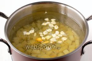 В кастрюлю с кипящей водой бросить подготовленный картофель и порезанный пластинками чеснок. Посолить по вкусу.