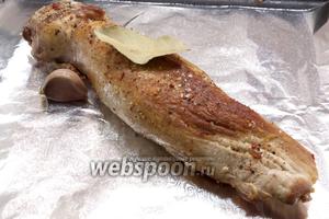 Обсыпать солью, чёрным молотым перцем, приправой для мяса. На двойной слой фольги выложить мясо, лавровый лист и зубок чеснока (не чистить). Завернуть и запекать в разогретой до 180°C духовке в течение 40 минут.