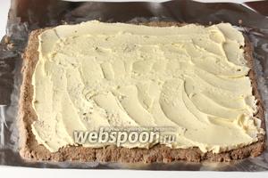 На печёночный паштет выкладываем желтковое масло и размазываем его по всей площади паштета, немного отступая от краёв. Это делать легко столовой ложкой, опущенной в горячую воду на несколько секунд и насухо вытертой.