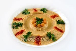 При подаче хумус поливаем арахисовым маслом, посыпаем небольшим количеством паприки и мелко нарезанной зеленью петрушки. Подаем с питой .