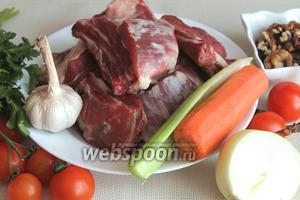 Для приготовления супа харчо нужно взять говядину с косточками, лук, морковь, грецкие орехи, сельдерей, помидоры, чеснок, хмели-сунели, лавровый лист, зелень кинзы и петрушки.