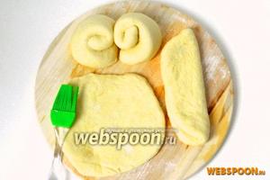 Каждый шарик из теста раскатываем, смазываем маслом и посыпаем сахаром. Затем складываем вдвое и сворачиваем в рулетики.