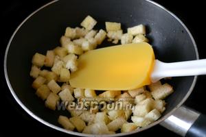 Срезаем корочки с ломтиков батона, нарезаем кубиками, сбрызгиваем оливковым маслом и подрумяниваем на сковороде.