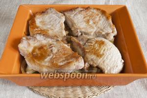 На лук поместить ломтики мяса. Немного посолить, добавить пряности по вкусу, влить в форму вино, закрыть фольгой или крышкой и запекать в духовке 30 минут при 190°C.