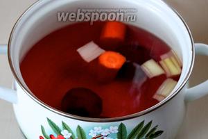 В кастрюлю наливаем 2-2,5 л воды, опускаем целиком свёклу, нарезанные крупными кусками половину нормы моркови, сельдерея, лука. Доводим до кипения, варим на медленном огне 30 минут.