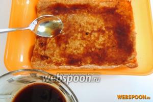 В любую коробку, которую можно будет закрыть, кладём 1 корж нижней стороной наверх и обильно пропитываем его 1/3 частью сиропа.