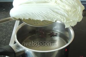 Над кипящей водой со звёздами аниса соорудим баню для листьев капусты. Самые большие 8 листьев солим, перчим и пропарваеим на бане, закрыв крышкой около 2 минут.
