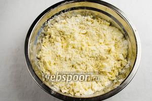 Просеянную муку насыпать в миску и руками быстро смешать с маслом и маргарином до консистенции сырого песка.