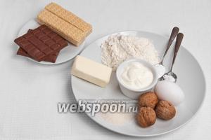 Основные ингредиенты: мука, масло, яйца, сахар, сметана, орехи, сода, ванилин, шоколад и вафли.