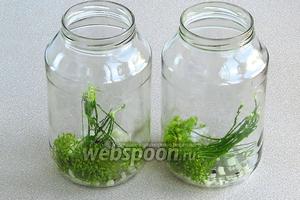 На дно стерилизованных банок выложить по 2 розетки укропа, горошины чёрного перца и рубленый чеснок.