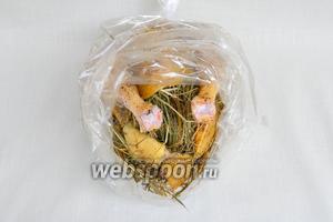 В середину маринованной курицы натолкать немного сена. Ещё чуть положить в мешок для запекания и сверху выложить куриную тушку.