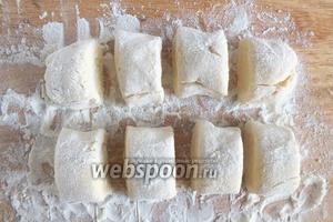 Раскатайте тесто на присыпанной мукой доске на жгуты, а заем нарежьте кусочками размером чуть больше грецкого ореха.