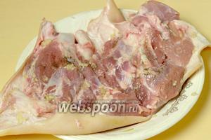 Если куски мяса внутри достаточно выпуклые, можно немного отбить/приплющить, после чего натираем рульку с двух сторон молотым перцем (0.5 ч. л.) и выдавленным через пресс чесноком (4 зубчика).