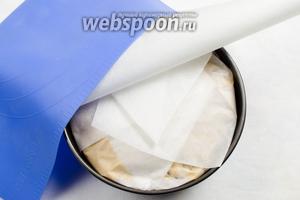 Плотно завернуть пергаментной бумагой форму. Сверху привернуть силиконовым ковриком или ещё одним слоем бумаги. Поставить в горячую духовку. Выпекать при температуре 140 °C в течение 3 часов до сухой лучины.