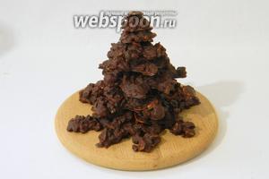 Для сборки ёлки расстапливаем столовую ложку шоколада и смазываем им каждую фигурку в центре. Выкладываем фигурки друг на дружку от большей к меньшей.