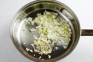 В разогретую сковороду с топлёным маслом выложить нарезанные кубиком лук и чеснок. Пассеровать до прозрачности.