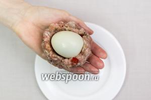 Яйца отварим, очистим. У меня были уже варёные яйца.
Из фарша сформируем лепёшку, выкладываем на неё яйцо...