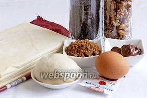 Для пирога понадобятся такие продукты: тесто слоёное дрожжевое, тесто пельменное, сахар коричневый, сахар белый, яйцо, шоколадная паста, ванилин, апельсиновая цедра, мак, орехи.